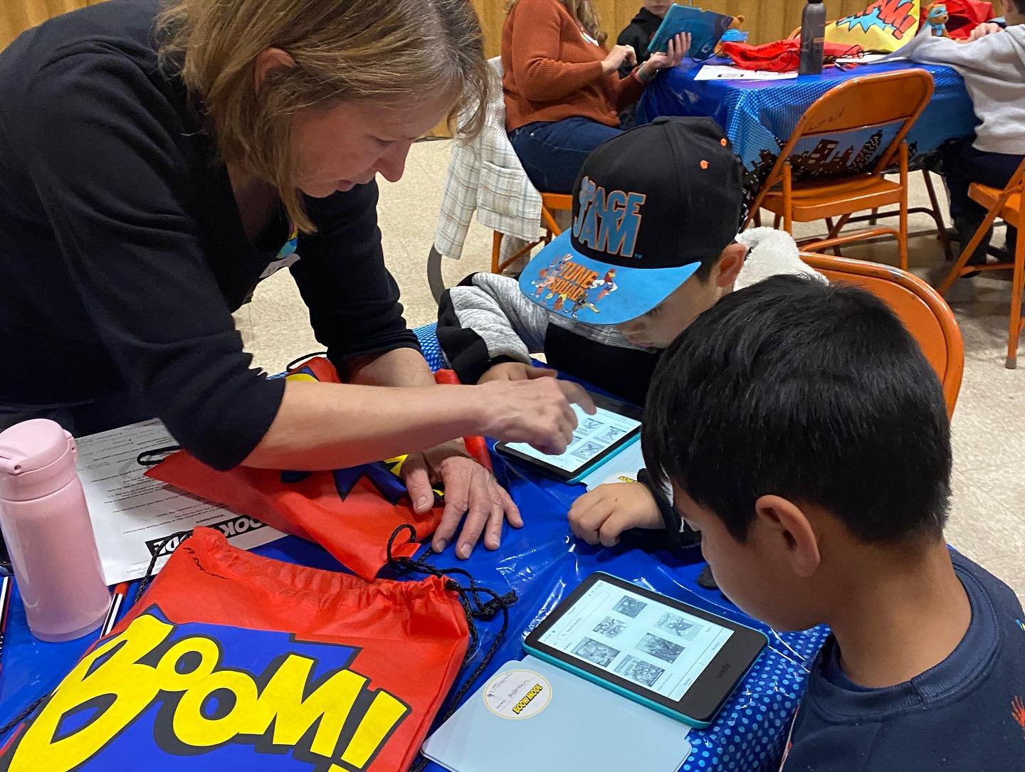A volunteer helping a student set up a new Kindle during BookMode