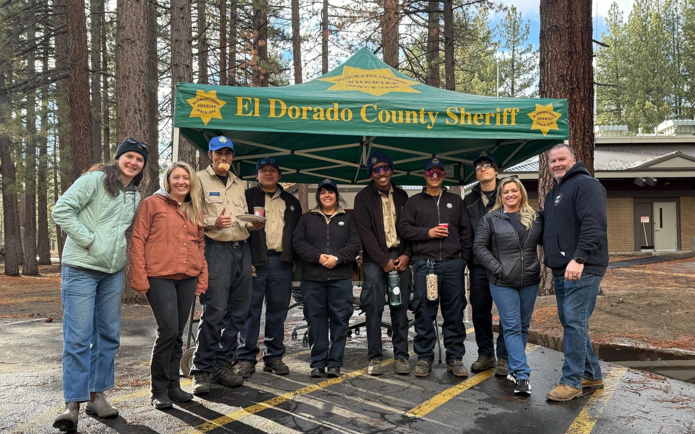 Volunteers from the 2025 holiday food drive gathered outside under the El Dorado County Sheriff tent